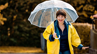 Keuchhusten-Vorsorge im Alter Frau mit Regenschirm