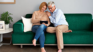 Älteres Paar liest auf Tablet