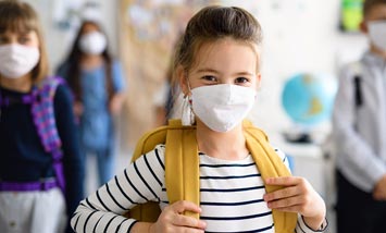 Nach Krankheit: Wann darf das Kind wieder in die Kita oder Schule? Kind trägt Maske in der Schule
